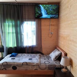Habitación pequeña con cama y ventana en Wooden house ,,Tsunda", en Vardzia