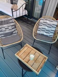 2 sillas y una mesa con una bandeja en el porche en BOSZKOWO Apartament "EDEL" 106 Aquarius en Boszkowo-Letnisko