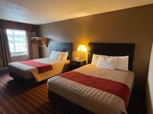 Connersville的住宿－伍德里奇客棧，酒店客房设有两张床和窗户。