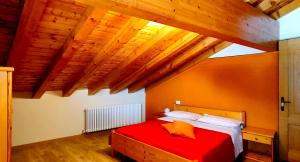 uma cama vermelha num quarto com tectos em madeira em Ristorante Bellavista con Locanda em Veleso