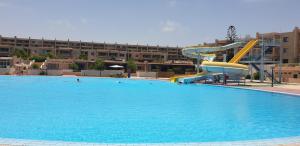 a large swimming pool with a slide in the middle at Zomoroda North Coast Chalet by Solid Pro in Dawwār Shindī Fannūsh