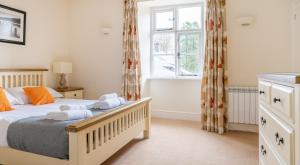 een slaapkamer met een bed en een raam bij Forge Cottage in Rusland