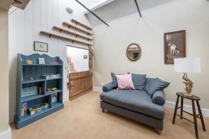 a living room with a blue couch and a staircase at Shockerwick Cottage in Bath