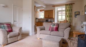 a living room with two chairs and a couch at Forge Cottage in Rusland