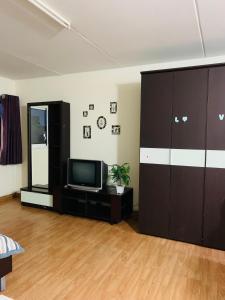 a living room with a tv and a cabinet at Condo poppular T8 fl14 in Thung Si Kan