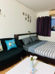 Condo poppular T8 fl14 في Thung Si Kan: غرفة معيشة مع سرير وأريكة