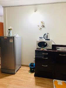 a kitchen with a refrigerator and a microwave at Condo poppular T8 fl14 in Thung Si Kan
