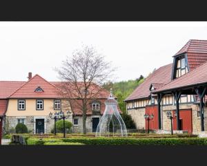 un edificio con una estatua en medio de un patio en Hotel Henriettenhof Weimarer Land, Weimar-Bad Berka en Bad Berka