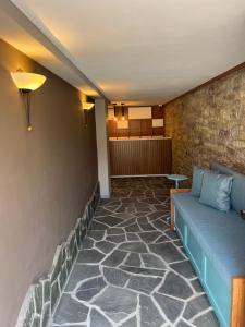 a living room with a couch and a brick wall at Palorto Hotel in Gjirokastër