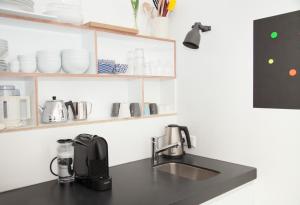a kitchen counter with a sink and a coffee maker at hip & stylish apartment in center, near trainstation, 15 min walk in Amsterdam