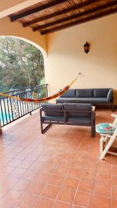 ein Wohnzimmer mit einem Sofa und einer Hängematte in der Unterkunft La Bastida : villa avec piscine in Le Moule
