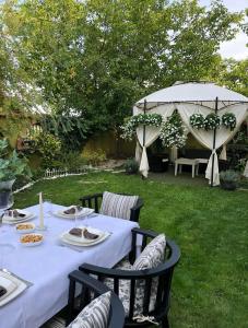 stół z białą ścierką i parasolem w obiekcie Lux Garden Home D w mieście Kumanowo