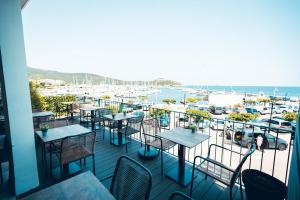balcón con mesas y sillas y vistas al puerto deportivo en Marina D'oro en Macinaggio
