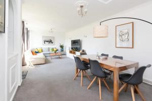 a white living room with a table and chairs at Spacious & Welcoming 4BD House - Kennington in London