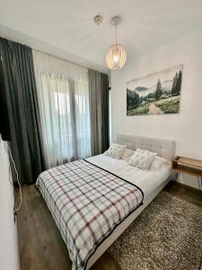 ポイアナ・ブラショフにあるApartament lux Poiana Brasov B23のベッドルーム1室(ベッド1台、プライド毛布付)