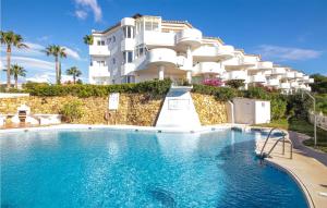 a hotel with a swimming pool in front of a building at Lovely Apartment In Mijas With Wifi in Mijas