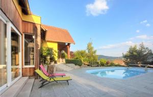 un patio con 2 sillas y una piscina en Cozy Home In La Vancelle With Outdoor Swimming Pool, en La Vancelle