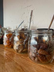 three jars of food sitting on a wooden table at LOGIS HOTEL - La Petite Rade in Le Havre