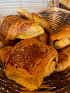 a bunch of pastries are sitting on a basket at LOGIS HOTEL - La Petite Rade in Le Havre