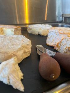 a grill with cheese and a knife on it at LOGIS HOTEL - La Petite Rade in Le Havre