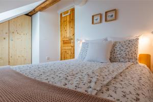 1 dormitorio con 1 cama grande y puerta de madera en Pr'Jernejc Agroturism, en Lesce