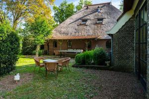 Delfstrahuizen的住宿－De Twee Zwanen，院子里有桌椅和猫的房子