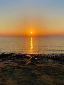 a sunset over the ocean with the sun setting at Paradise Karpaz Hotel & Restaurant in Rizokarpaso