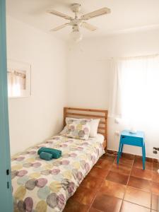 1 dormitorio con cama y mesa azul en Timfay, en Corralejo