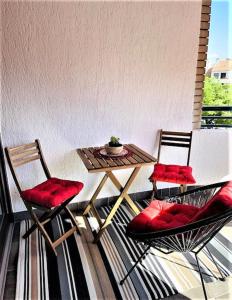 twee stoelen en een tafel op een balkon met een tafel bij Apartman Ines in Rijeka