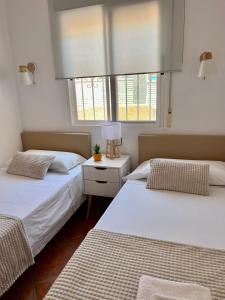 two beds in a room with two windows at Villa Bon Dia in Calpe