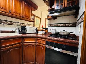a kitchen with wooden cabinets and a stove top oven at Apartamento Alvarez in Cartagena de Indias