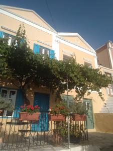 een gebouw met potplanten ervoor bij ALEMINAS HOUSE in Symi
