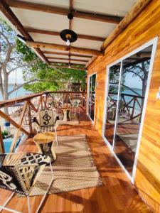 - une terrasse couverte en bois avec des chaises et des tables dans l'établissement Freedom Beach Club, à Barú