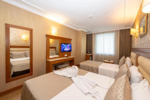ein Hotelzimmer mit zwei Betten und einem Spiegel in der Unterkunft Dalan Otel Istanbul Old City in Istanbul + 47 Fotos