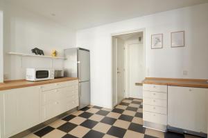 a kitchen with a refrigerator and a checkered floor at 2BR in Vibrant & Colourful Nyhavn Copenhagen City in Copenhagen