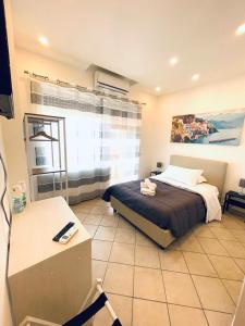 Schlafzimmer mit einem Bett, einem Tisch und einem Fenster in der Unterkunft B&B OFF Rooms and Relax in Neapel