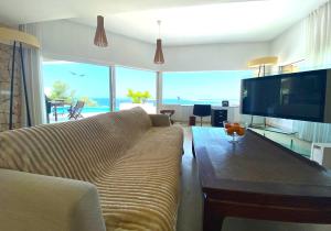 a living room with a couch and a flat screen tv at Ibiza 7th Heaven Villa in Sant Josep
