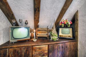 two old televisions sitting on top of a wooden dresser at Dworek Sanocki in Sanok