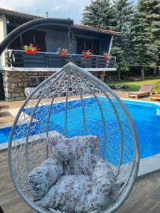 a hanging chair with pillows next to a pool at Villa "Hipnotic" in Sarajevo