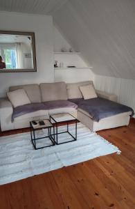 ein Wohnzimmer mit einem Sofa und einem Tisch in der Unterkunft Les embruns in Saint-Philibert