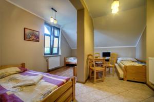a bedroom with two beds and a table in it at Dworek Sanocki in Sanok