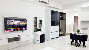 a kitchen with white cabinets and a table and chairs at Chambers Serviced Suites KLCC by Cozy Stay in Kuala Lumpur