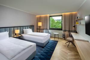 柏林DoubleTree by Hilton Berlin Ku'damm的有两张床和一张书桌的酒店房间 更多37张照片