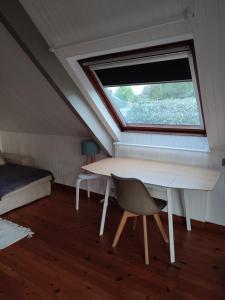 een tafel en een stoel in een kamer met een raam bij Les embruns in Saint-Philibert