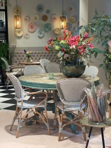 a table with chairs and a vase with flowers on it at Bubbles & Bed in Bilthoven