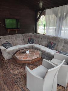a living room with a couch and a table and chairs at Boszkowo Domki-Stonki in Boszkowo