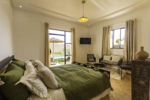 Villa Essaouira petit déjeuner compris في الصويرة: غرفة نوم مع سرير وغرفة معيشة
