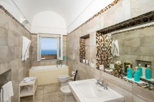 a bathroom with a sink and a toilet and a window at Villa Marilu Praiano in Praiano +38 photos