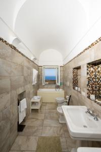 a bathroom with two toilets and a sink and a tub at Villa Marilu Praiano in Praiano