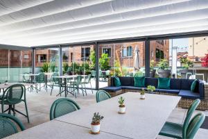 un patio con tavoli, sedie e divano di CO99 Art Building Residence a Milano